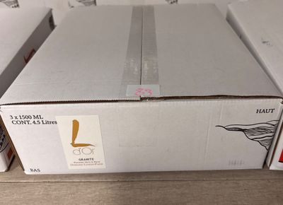 une boîte de vin posée sur une table à côté d'une bouteille de vin