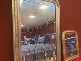 deux miroirs posés sur une étagère rouge dans un magasin
