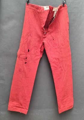 un pantalon rouge suspendu à un portant