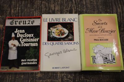 trois livres posés sur une table, avec un chef debout à côté
