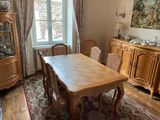 une table et des chaises dans une pièce avec une grande fenêtre
