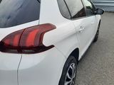 the rear end of a white car parked in front of a building