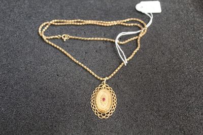 un gros plan d'un collier en or orné d'un médaillon