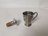 a silver cup with a cork stopper next to it