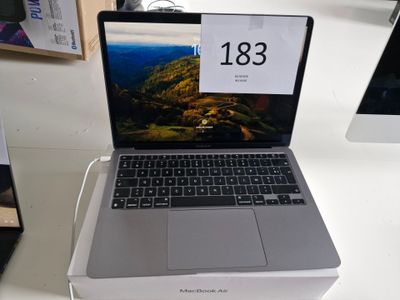 un ordinateur portable posé sur une table blanche