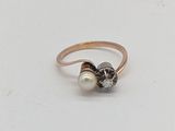 une image représentant une bague en or sertie d'une perle et d'un diamant