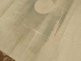 a white area rug on the floor with a brown area rug on the floor
