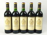 quatre bouteilles de vin sont alignées sur une surface blanche
