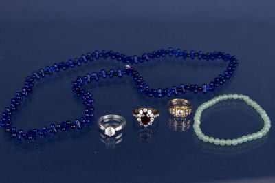 un collier de perles bleues orné d'une bague, d'un bracelet et d'une bague