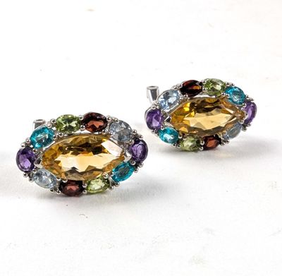 une paire de boucles d'oreilles en cristal multicolores posées sur un fond blanc