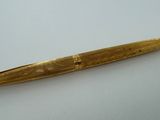 an image of a gold pen sitting on top of a white table