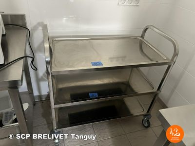 a stainless steel cart with a blue tag on it in a kitchen