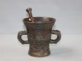 a metal cup with a spoon in it on a table