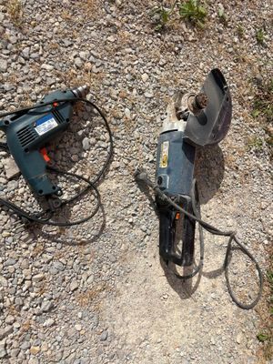 a drill and a cord on the ground next to a drill