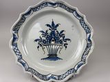 a blue and white plate with a flower arrangement on it