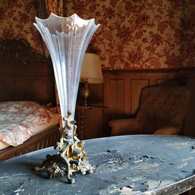 un vase en verre posé sur une table en marbre dans une chambre