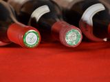 several bottles of wine are lined up on a red cloth