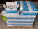 Des cartons d'eau « Mission » sont empilés sur une palette dans un entrepôt