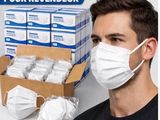 un homme portant un masque, à côté d'une boîte de masques jetables