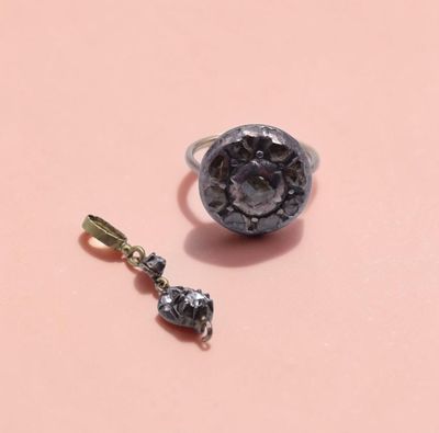 une image représentant une bague et un pendentif sur un fond rose