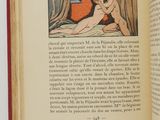 an open book with a picture of a naked woman laying on a bed