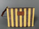a yellow and brown striped purse with a brown leather handle