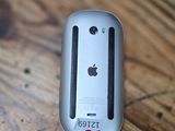 an apple computer mouse sitting on a wooden table