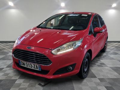 une Ford Fiesta rouge garée dans un garage au sol carrelé