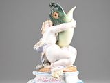 a figurine of a woman holding a fish on top of a table