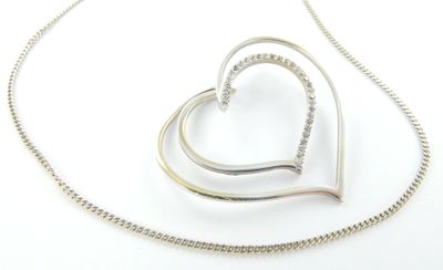 pendentif en forme de cœur en argent sterling, suspendu à une chaîne en argent, sur fond blanc