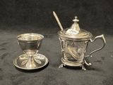 une tasse et une soucoupe en argent posées l'une à côté de l'autre