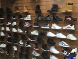many pairs of shoes hanging on the wall in the store