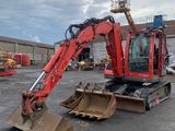 a red excavator that is sitting in a parking lot