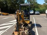 a small bulldozer parked in a parking lot next to a truck