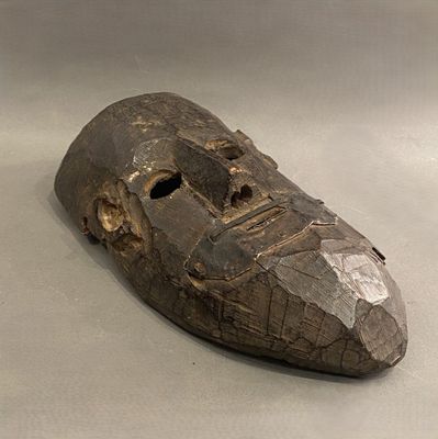 un masque en bois posé sur une table