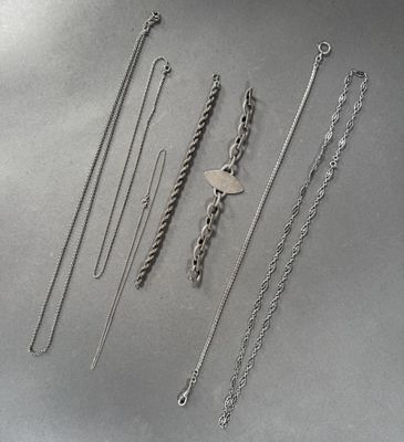 une collection de colliers et de bracelets en argent posés sur une table