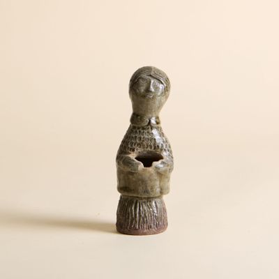 une petite statue représentant une femme tenant un chat