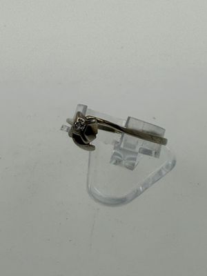 a silver ring with a diamond on it on a clear surface