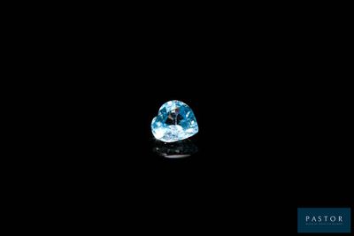 a close up of a blue topaz diamond on a black surface