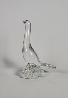 un oiseau en verre perché sur un rocher