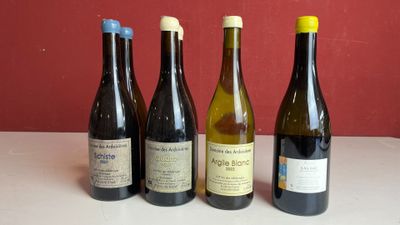 quatre bouteilles de vin sont alignées sur une table