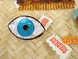 a picture of a hair comb with a blue eye on it