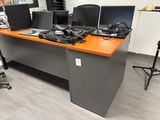 a desk with a lot of computers on it in a room
