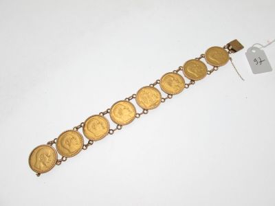 un gros plan d'un bracelet orné de pièces d'or