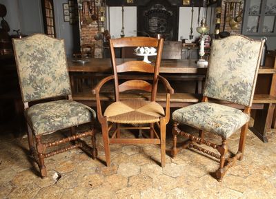 plusieurs chaises et une table dans une pièce avec une cheminée en arrière-plan