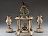 une horloge posée sur une table, à côté de deux vases