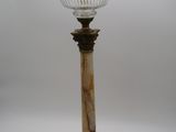une lampe à l'ancienne surmontée d'un abat-jour en verre