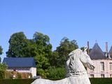 a statue of a horse that is sitting in the grass