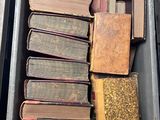 many old books in a metal box on the floor