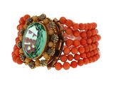 an image of a bracelet with orange beads and a green stone
